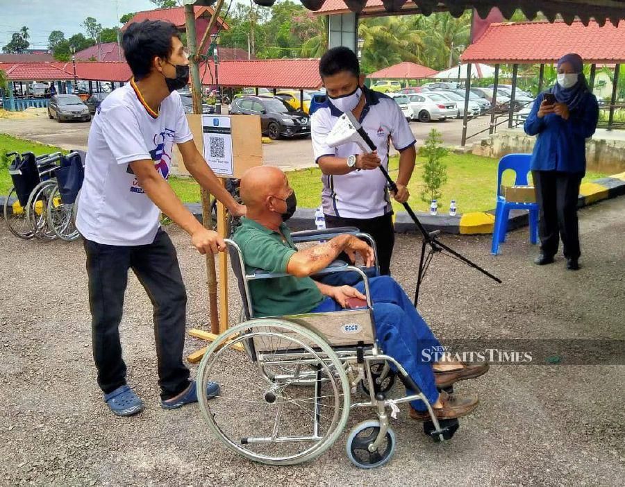 Volunteers helping vaccine recipients get to their checkpoints. - NSTP/ZAINAL AZIZ