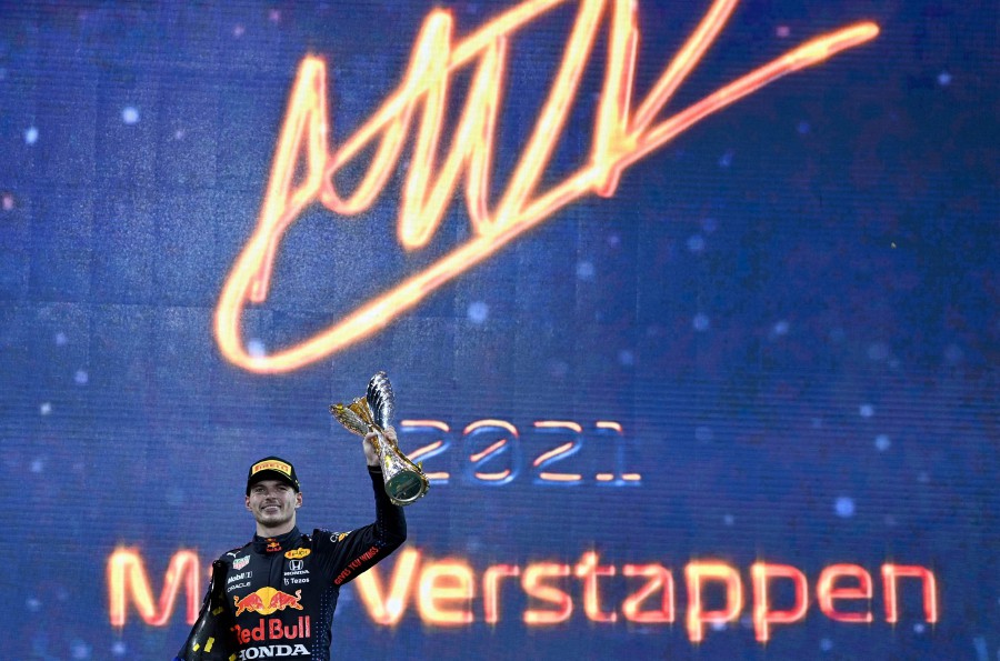 2021 FIA Formula One World Champion Red Bull's Dutch driver Max Verstappen celebrates on the podium of the Yas Marina Circuit after the Abu Dhabi Formula One Grand Prix on December 12. - AFP PIC