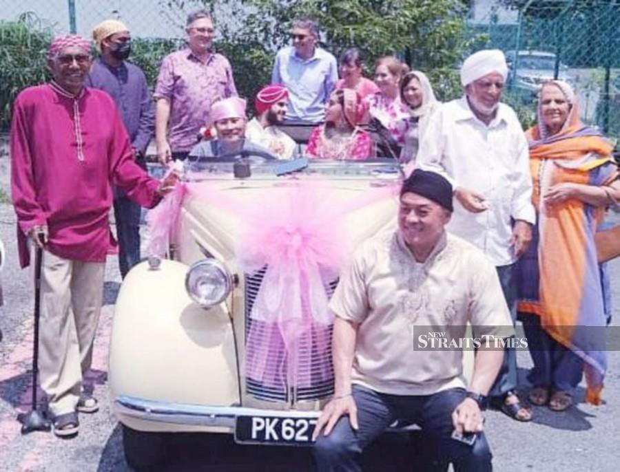 Stanley Yeong (at the wheels) and wedding couple Major Manvikram Singh Gill and Manpreet Kaur (in back seat) join Rear-Admiral (Rtd) Tan Sri K. Thanabalasingam (left), Major-General (Rtd) Datuk Toh Choon Siang (seated right, front) and the other multi-racial guests at the Gurdwara Sahib Pulapol, Police Training Centre in Jalan Semarak, Kuala Lumpur. -- Pic: ADRIAN DAVID/NSTP