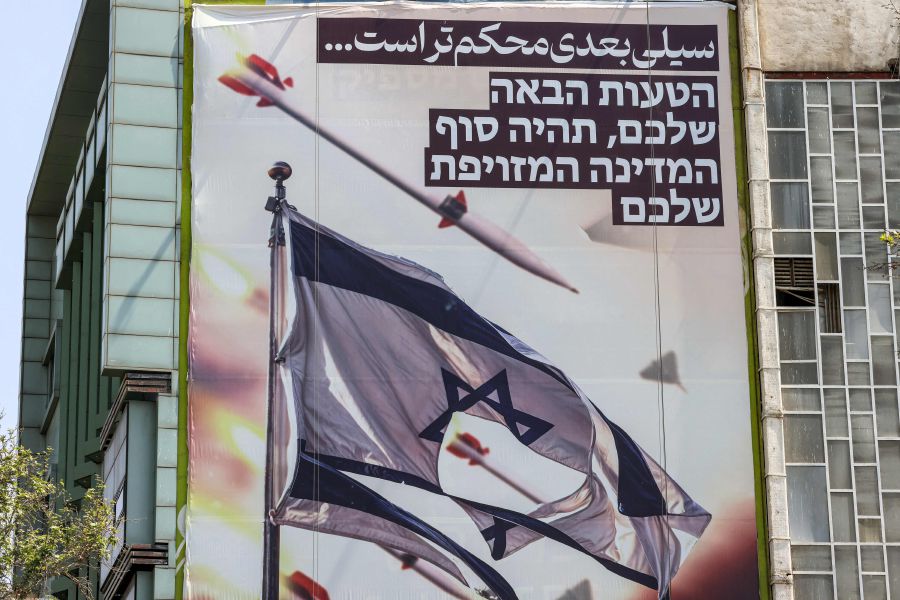 A banner — depicting missiles and drones flying past a torn Israeli flag, with text in Persian reading ‘the next slap will be harder’ and in Hebrew ‘your next mistake will be the end of your fake state’ — hangs on a building at Palestine Square in Teheran, Iran, on Sunday. - AFP pic