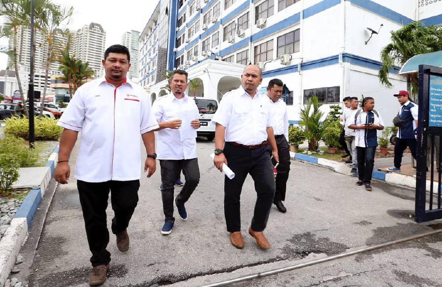 Umno Youth vice chief Anuar Faisal Yahaya (second from right) at the George Town northeast district police headquarters this afternoon. Pix by Mikail Ong