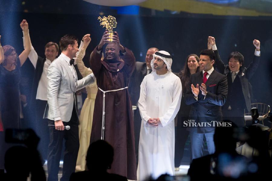 (From left) Hugh Jackman, Peter Tabichi, Crown Prince Sheikh Hamdan, and Sunny Varkey during the award ceremony. NSTP/HAZLINA AZIZ