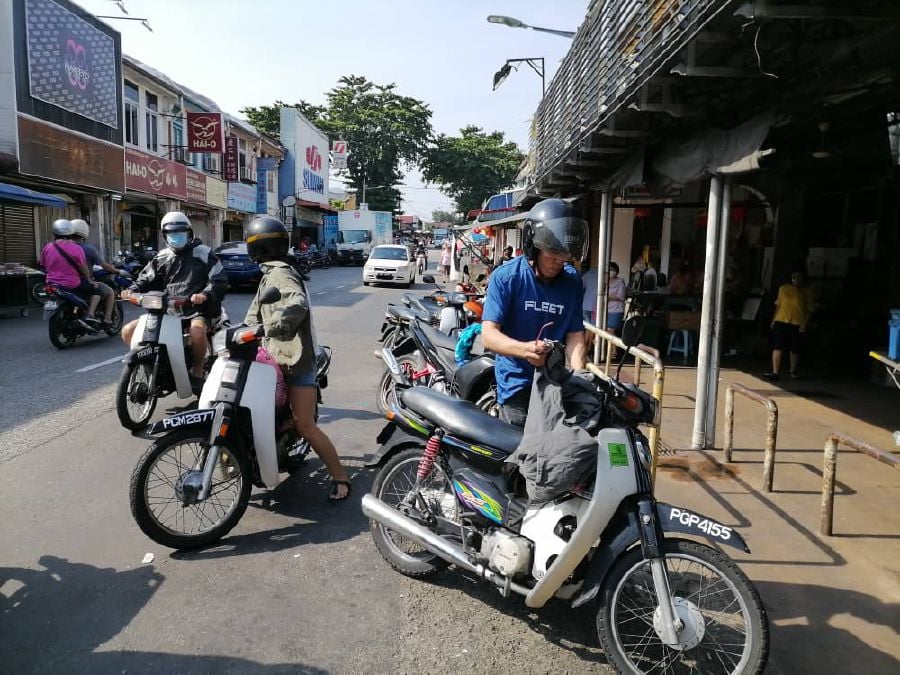 Some of the motorists seen at Air Itam market today. - NSTP/Zuhainy Zulkiffli
