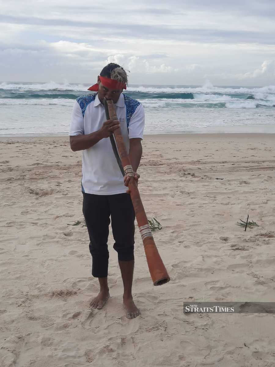 An aboriginal musician performing with the didgeridoo by the Gold Coast.
