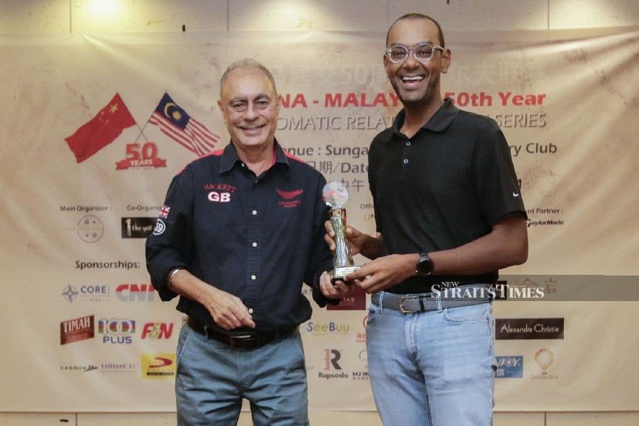 NST executive editor Sharanjit Singh, presenting prizes to one of the winners of the China-Malaysia Diplomatic Relations Golf Series at Sungai Long Golf and Country Club, Kajang. -- NSTP/AIZUDDIN SAAD