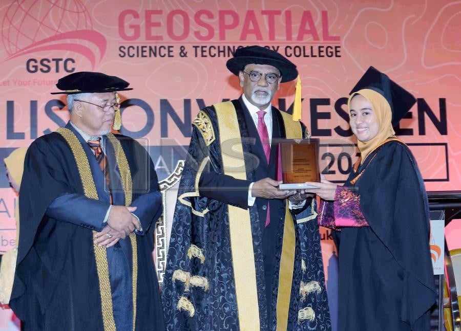  Water, Land and Natural Resources Minister Dr Xavier Jayakumar with Geospatial Science and Technology College rector/chief executive Kamaludin Mohd Omar (left) presents an award to Nina Nadia Che Daud during the convocation ceremony at Dewan Prima Wisma LJT. - NSTP/SAIFULLIZAN TAMADI.