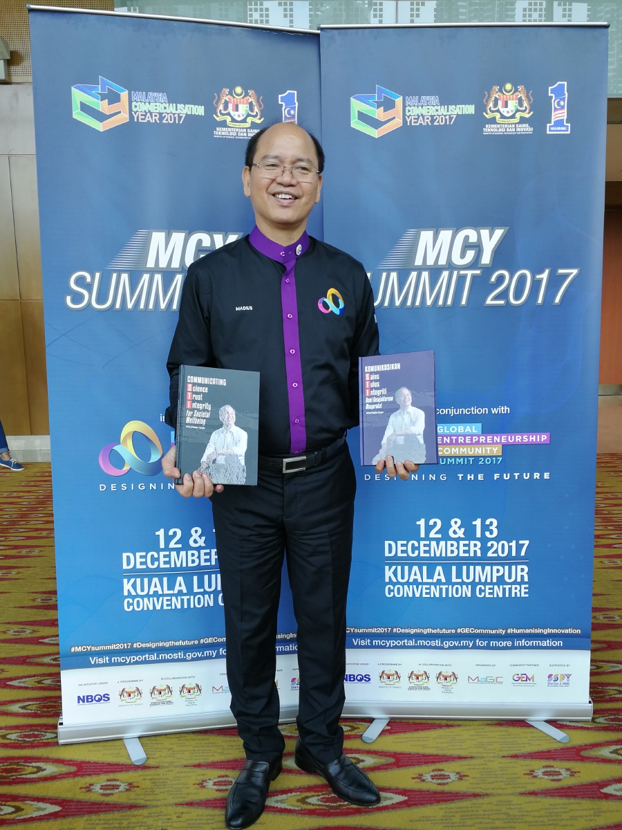  Science, Technology and Innovation Minister Datuk Seri Wilfred Madius Tangau holds copies of the book during the launch at Kuala Lumpur Convention Centre. 