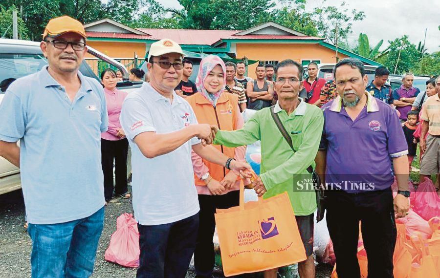 Tellian State Assemblyman, Yussibnosh Balo (second from left) handed over food supplies from JKM to Tuai Rumah, Umpang Menang at Jalan Dijih, Selangau. NSTP/HARUN YAHYA