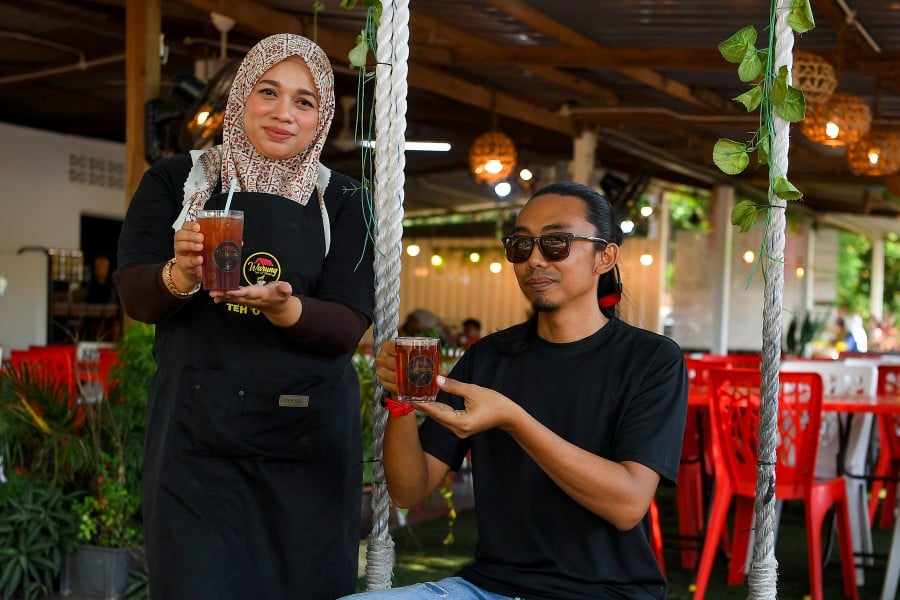 Rohaizad Abdul Khalid and Yusnira Mukhtar a their Warung Teh ‘0’ 50 Sen stall in Kg Bagan Pinang in POrt Dickson. - BERNAMA PIC