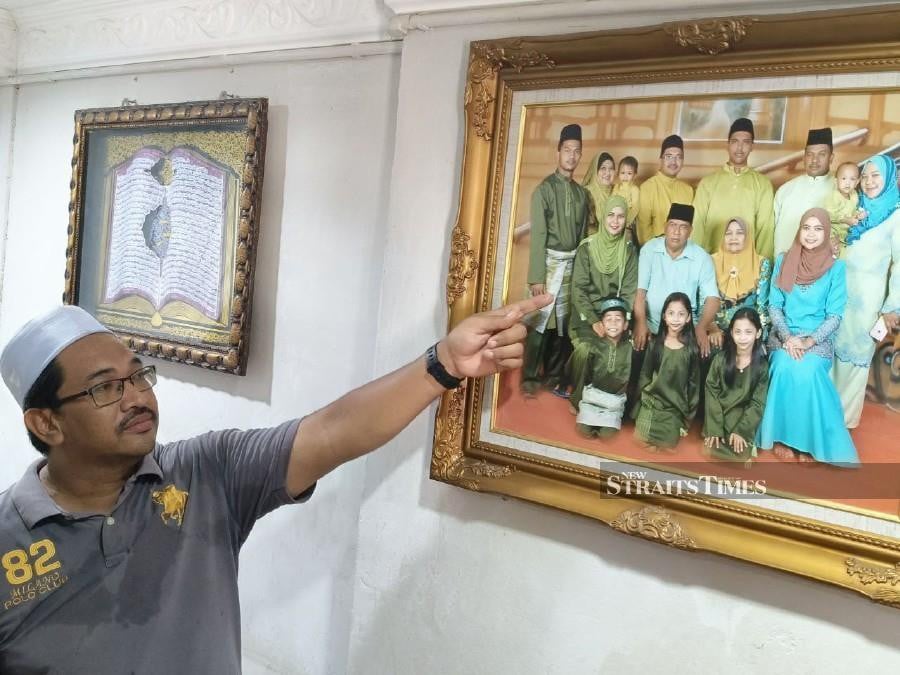 Abdul Latif pointing to his sister Petty Officer TNL Noor Rahiza Anuar in a family picture. Noor Rahiza was among 10 Royal Malaysian Navy (RMN) officers who died in a helicopter crash in Lumut earlier today. NSTP/Zuliaty Zulkiffli