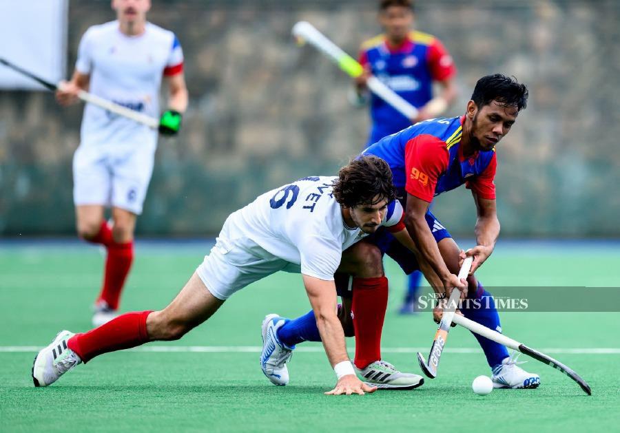 Malaysia’s Faizal Saari (in blue-red) in action against Austria in Sunday’s Nations Cup classification match in Gniezno, Poland. PIC FROM FIH 