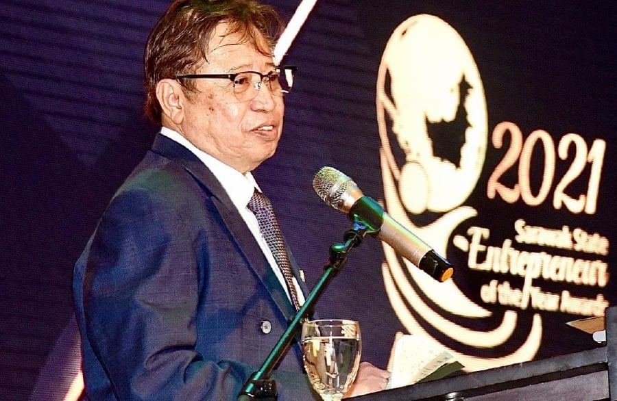 Sarawak Chief Minister Tan Sri Abang Johari Openg presenting the Sarawak Entrepreneur of the Year 2021 (EOYS) Awards to one of the recipients in Kuching today. -- Pic courtesy of UKAS