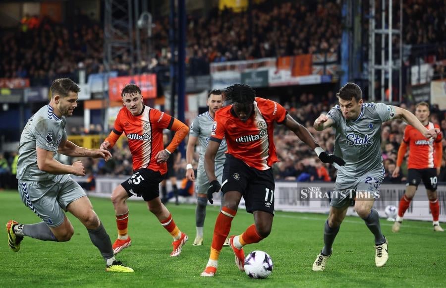 Luton’s Elijah Adebayo (centre) in action with Everton’s James Tarkowski (left) and Seamus Coleman during Friday’s Premier League match at Kenilworth Road in Luton. - AFP PIC