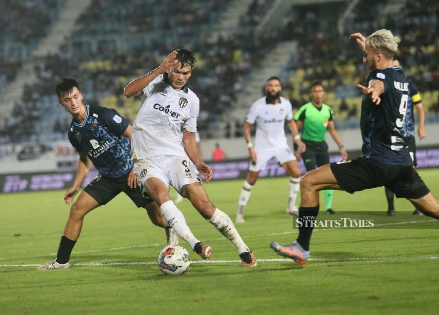 Terengganu’s Adisart Kraison (centre) tries to evade a tackle by KL City’s Giancarlo Gallifuoco (right) during the match at the Sultan Mizan Zainal Abidin Stadium in Kuala Terengganu. - NSTP/GHAZALI KORI