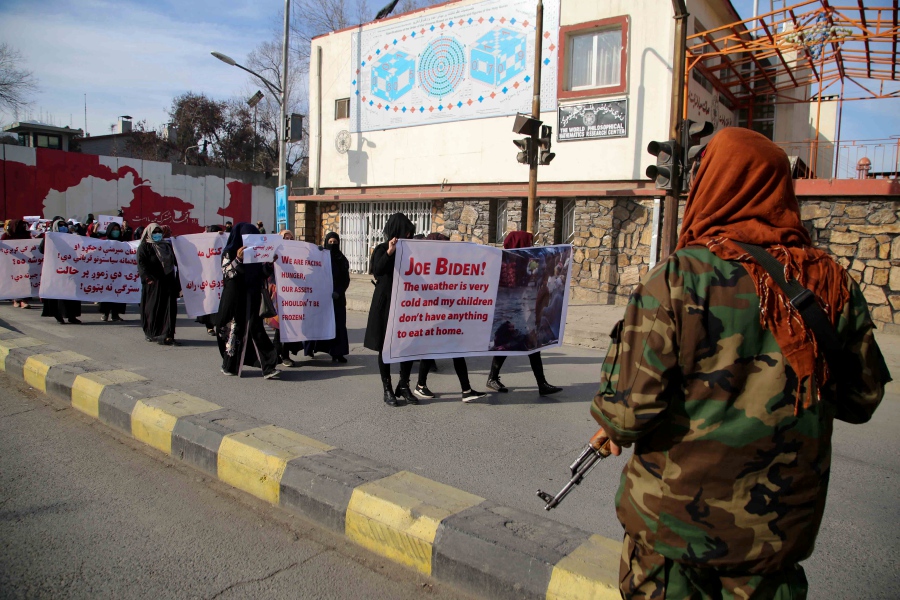 Taliban stand guard as women carry placards during a rally demanding from the US and international community to unfreeze the country's assets, during a protest in Kabul, Afghanistan, 29 December 2021. The Taliban government has issued an open letter to the United States Congress asking it to end sanctions against Afghanistan, resume the flow of aid and unfreeze assets in Afghan banks, in the view of the ongoing crisis in the country. Afghanistan has been experiencing a severe humanitarian crisis as people have no job or income and many were forced to sell their belongings for food. Banks have resumed operations with limited cash flow. - EPA pic