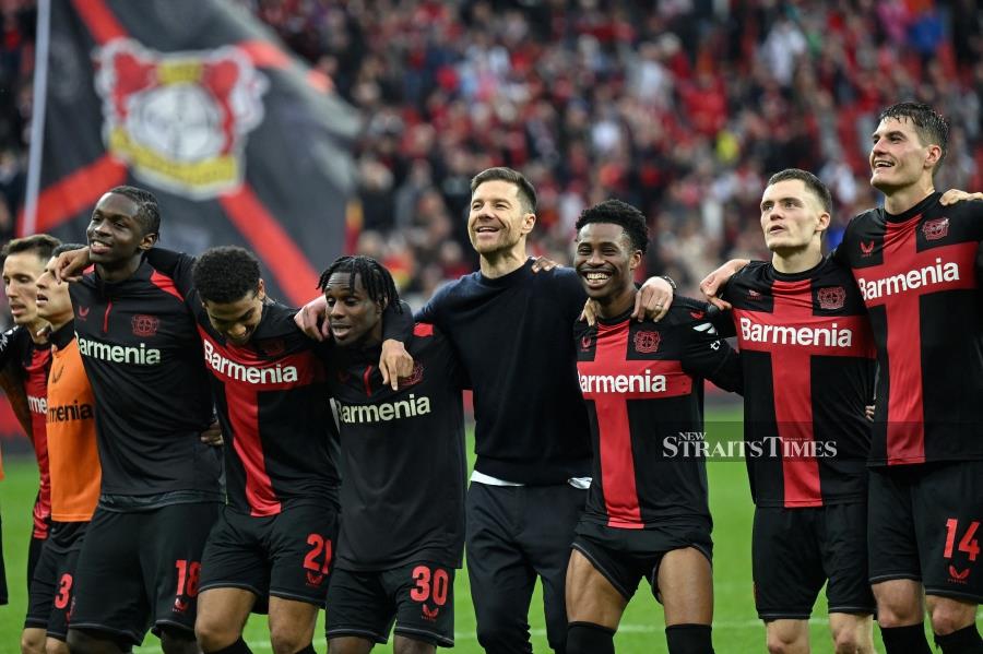 Bayer Leverkusen coach Xabi Alonso (centre) and his players celebrate winning the Bundesliga match against TSG 1899 Hoffenheim in Leverkusen, western Germany on March 30. AFP PIC