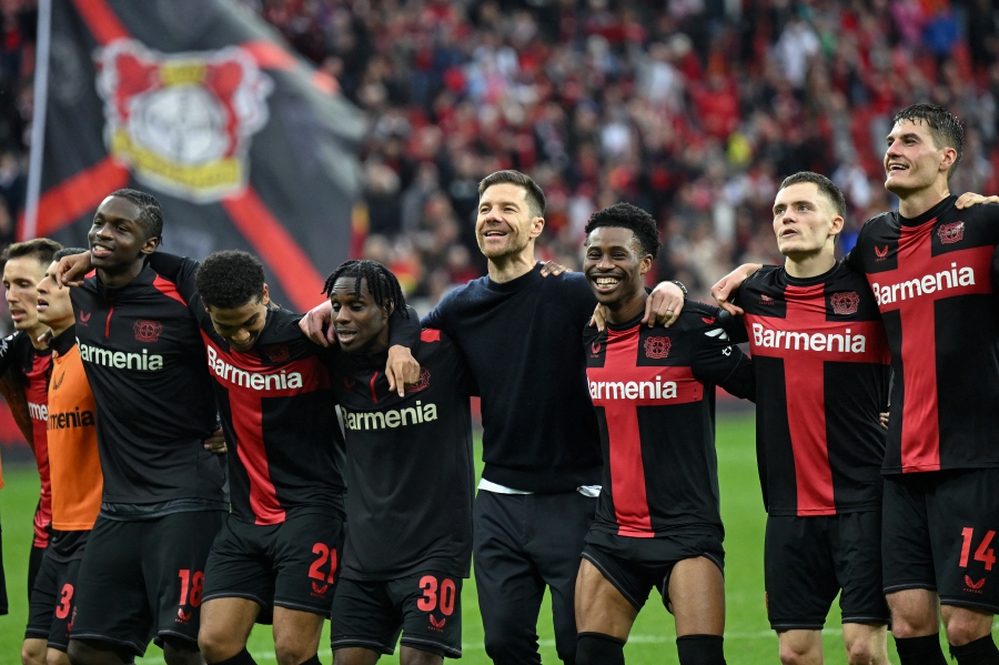 Bayer Leverkusen's Spanish head coach Xabi Alonso (cente) and his players celebrate winning the German first division Bundesliga football match Bayer 04 Leverkusen v TSG 1899 Hoffenheim in Leverkusen, western Germany. (Photo by INA FASSBENDER / AFP) 