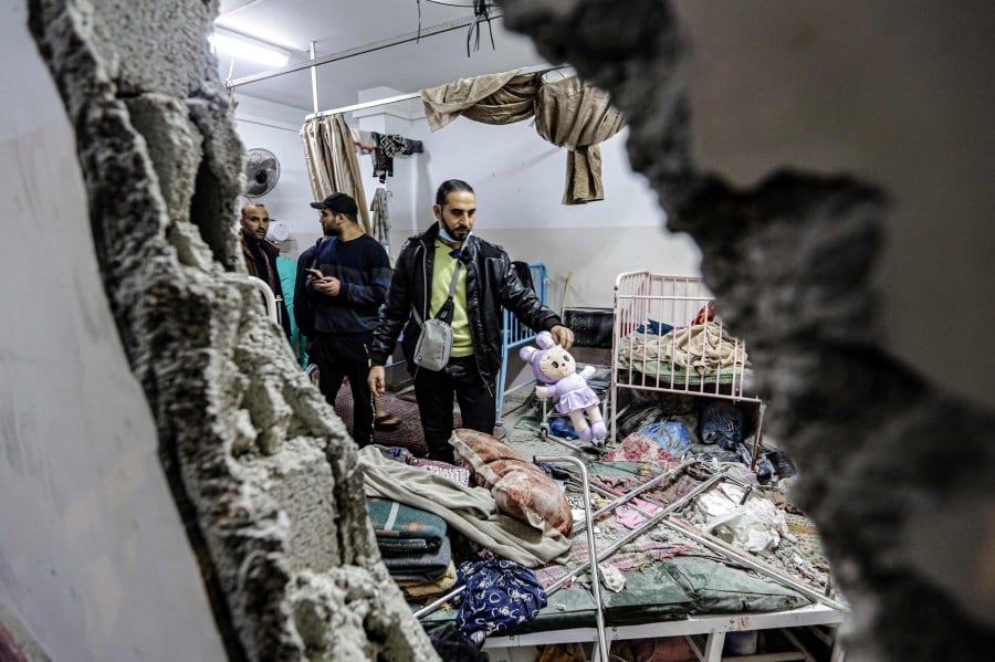 People inspect the damage in a room following Israeli bombardment at Nasser hospital in Khan Yunis in the southern Gaza Strip. - AFP PIC