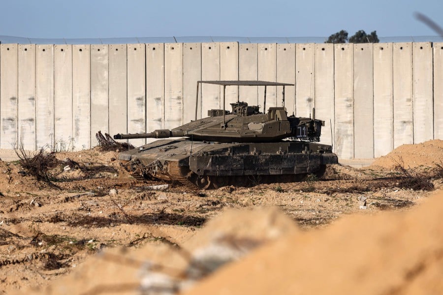  An Israeli Tank rolling along the Israeli Gaza border near the city of Beit Lahia in the northern Gaza Strip. - AFP PIC