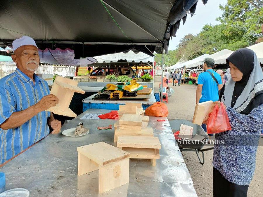  Ibrahim Ujam deals with customers who are interested in his products in Batu Berendam, Melaka. - NSTP/NAZRI ABU BAKAR