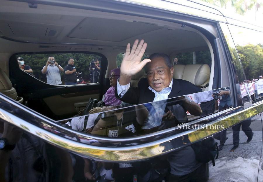 Tan Sri Muhyiddin Yassin waves as he arrives at the Kuala Lumpur Courts Complex ahead of the trial. - NSTP/EIZAIRI SHAMSUDIN