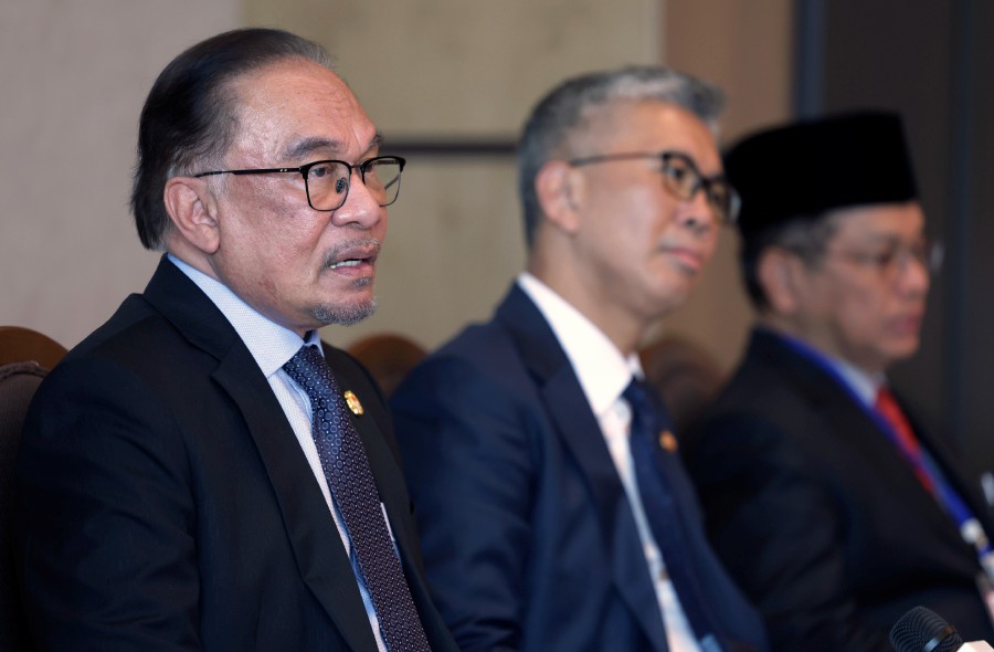 Prime Minister Datuk Seri Anwar Ibrahim at a press conference in Samarkand, Uzbekistan. With him are Investment, Trade and Industry Minister Tengku Datuk Seri Zafrul Abdul Aziz (centre) and Department (Religious Affairs) Datuk Dr Mohd Na’im Mokhtar (right). -- BERNAMA PIC