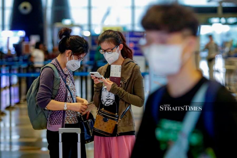 This March 7 pic shows passengers wearing face masks at Kuala Lumpur International Airport. -NSTP/AIZUDDIN SAAD