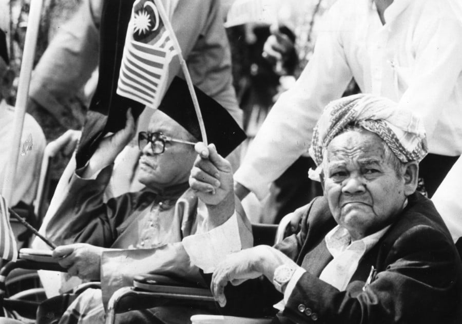 Despite being on wheelchairs, two independence fighters and opposition of the Malayan Union didn't want to miss the National Day parade. Picture taken on Aug 31, 1986.