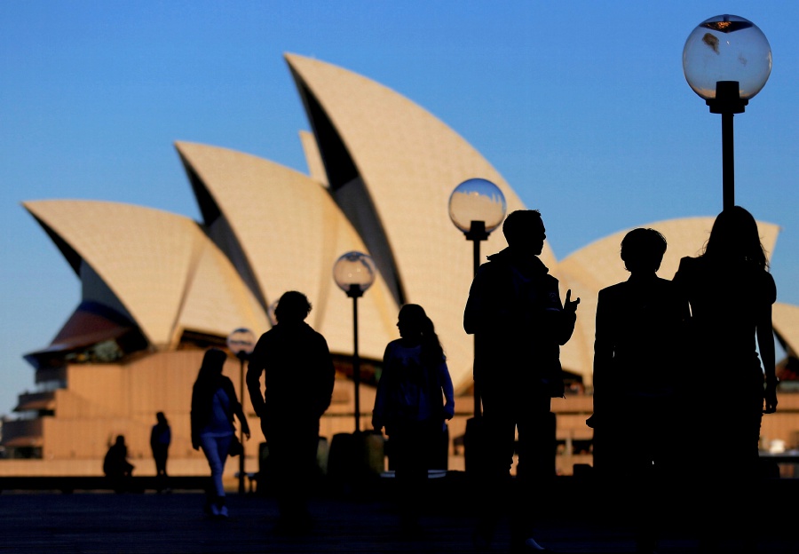 (FILE PHOTO) People are silhouetted against the Sydney Opera House at sunset in Australia. (REUTERS/Steven Saphore/File Photo)
