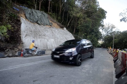 Light vehicles were allowed access at Jalan Teluk Bahang - Jalan Balik Pulau after it was reopened to motorists. Pix by SHAHNAZ FAZLIE SHAHRIZAL. 