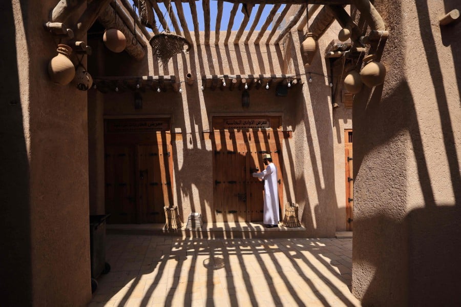 An Omani man opens his shop at Bahla Fort, one of four historical forts located at the foot of the Green Mountain highlands of Oman, and the only fort in the country designated a UNESCO Heritage Site, in Bahla. - AFP PIC