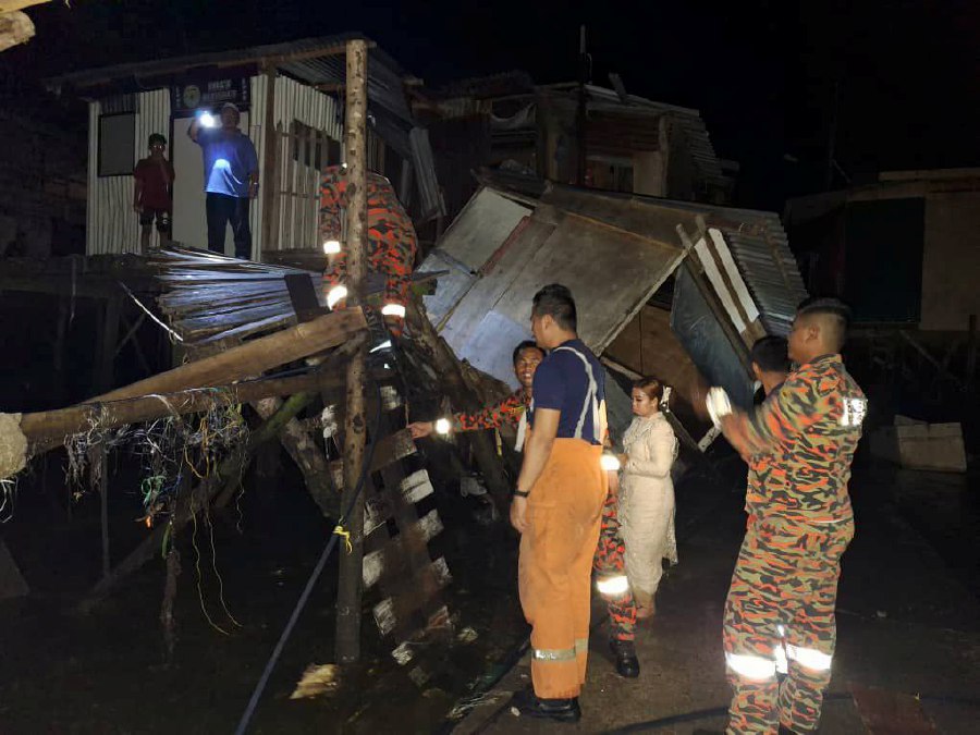 Four injured, a house damaged and a motorcycle fell into the sea after a 300-metre bridge collapsed at Kampung Bangau Bangau. - Pic courtesy of Bomba