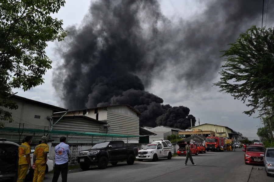 Smoke billows from the site of an explosion and fire at a plastics factory on the outskirts of Bangkok on July 5, 2021. (Photo by Lillian SUWANRUMPHA / AFP)