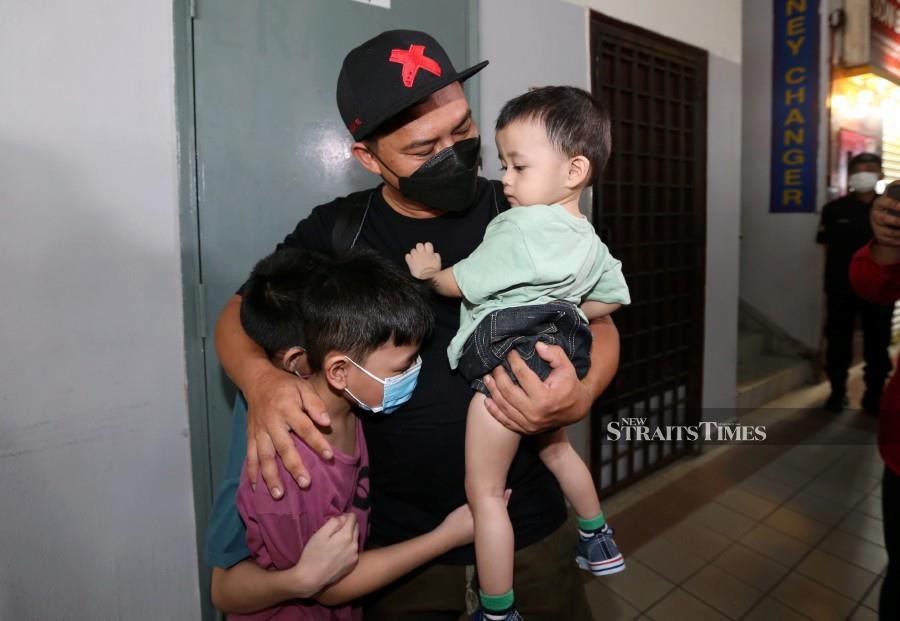  Bali Anak Jalang embraces his children at the at the Larkin Sentral Terminal. -NSTP/NUR AISYAH MAZALAN  