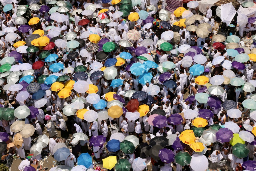 Muslim pilgrims use umbrellas to shield themselves from the sun as they gather to attend noon prayers outside Nimrah Mosque at the Plain of Arafat during the annual haj pilgrimage, outside the holy city of Mecca, Saudi Arabia, June 15, 2024. REUTERS
