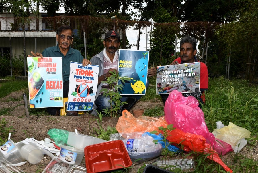 onsumers Association of Penang (CAP) Senior Education Officer N V Subbarow (left) with his employees B Sivanathan (right) and T Selvam show a plastic pollution banner in front of a pile of plastic, in conjunction with the World Earth Day celebration. - BERNAMA pic