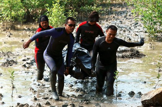 Firemen carry the remains of Lee Choon Chin, 31, who drowned along a riverbank in Batu Kawan while fishing for crabs.Pix by AMIR IRSYAD OMAR. 