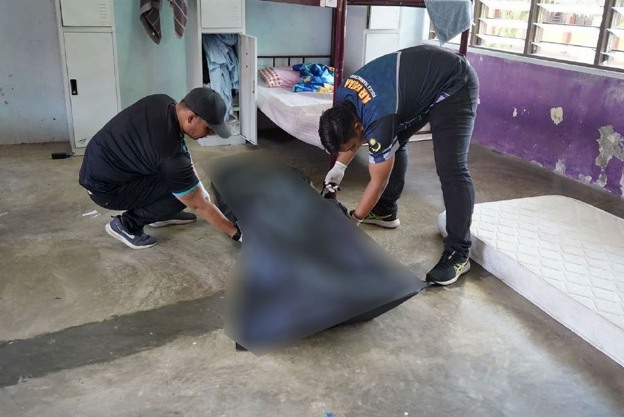 Police officers conducting investigations on the body of the victim. Pic courtesy of PDRM