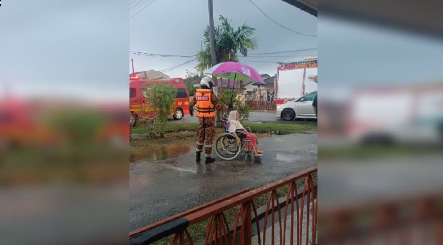  Firemen rescue a senior citizen whose house on Jalan Melur 1, Sungai Kantan here was submerged in flood waters. — PIC COURTESY OF FIRE & RESCUE DEPT 