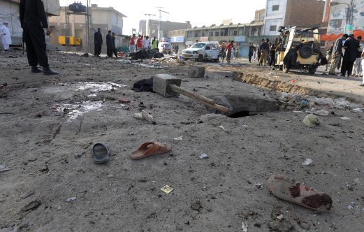 Pakistani security officials examine the site of a bomb explosion in Quetta on September 13, 2014. A bomb explosion on a busy road killed two and wounded at least 17 people including two paramilitary soldiers in Pakistan's southwestern Baluchistan province, security officials said. AFP PHOTO