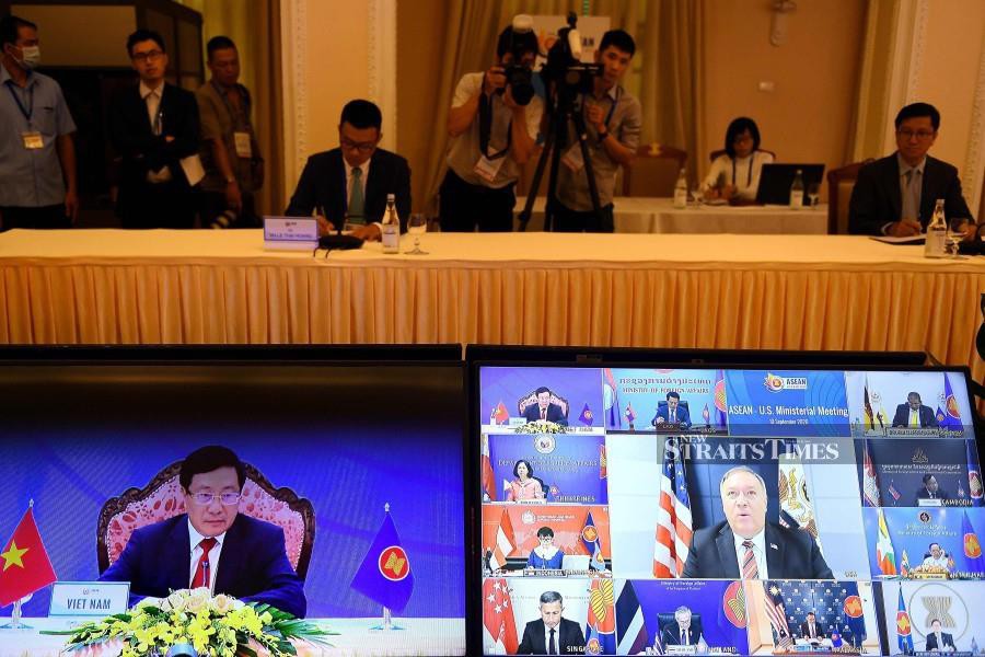 Vietnam's Foreign Minister Pham Binh Minh (left) and US Secretary of State Mike Pompeo (centre, on screen at right) are seen on monitor screens during the Association of Southeast Asian Nations (ASEAN)-US Ministerial Meeting, held online due to the Covid-19 novel coronavirus pandemic, in Hanoi. China accused the US of becoming "the biggest driver of militarisation" in the contested South China Sea, as tensions between Washington and Beijing look set to swamp a regional Asian summit. - AFP photo