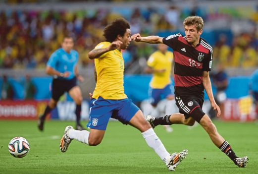 German player Thomas Mueller (R) vies for the ball with Brazil's Marcelo during the FIFA World Cup 2014 semi final match between Brazil and Germany at the Estadio Mineirao in Belo Horizonte, Brazil. EPA Photo.