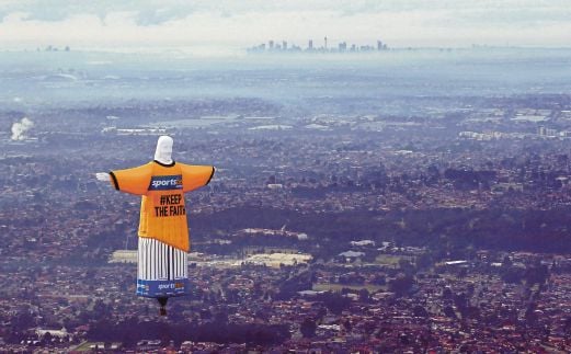  A giant hot air balloon in the shape of Brazil’s Christ The Redeemer statue in an Australian football jersey flying over the Sydney skyline in support of the Australian team ahead of the 2014 World Cup in Brazil.--AFP Photo