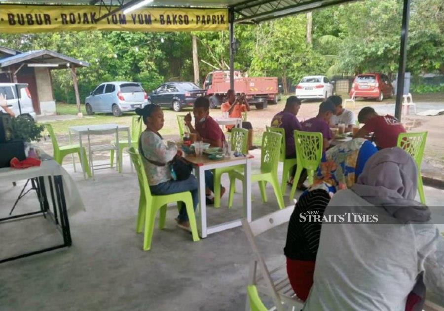Customer enjoying their meals at the stall in Simpang Baba. - Pic by Zainal Aziz 