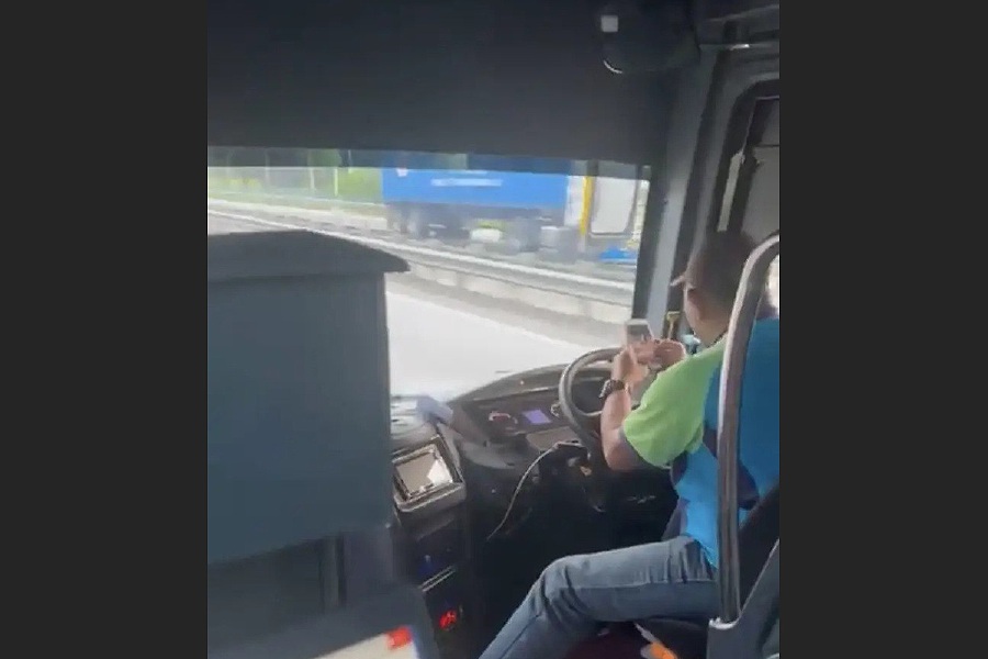 A bus driver was slapped with a summon after he was caught on video using his mobile phone while driving. - Pic source from Social Media