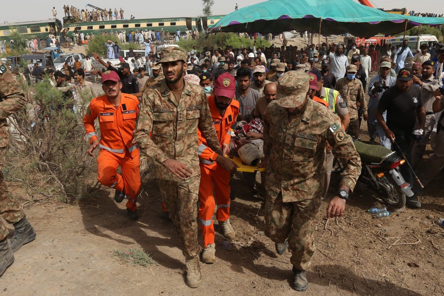 Security personnel carry an injured passenger to an army helicopter at the site of a train accident in Daharki area of the northern Sindh province. - AFP Pic