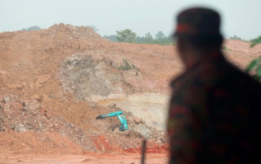 A Fire and Rescue Department Officer monitors the soil movement at a sand mine where a cave in occurred earlier. An Indonesian worker died while another is still missing from incident that happened on Friday morning. Pix by Hairul Anuar Abd Rahim