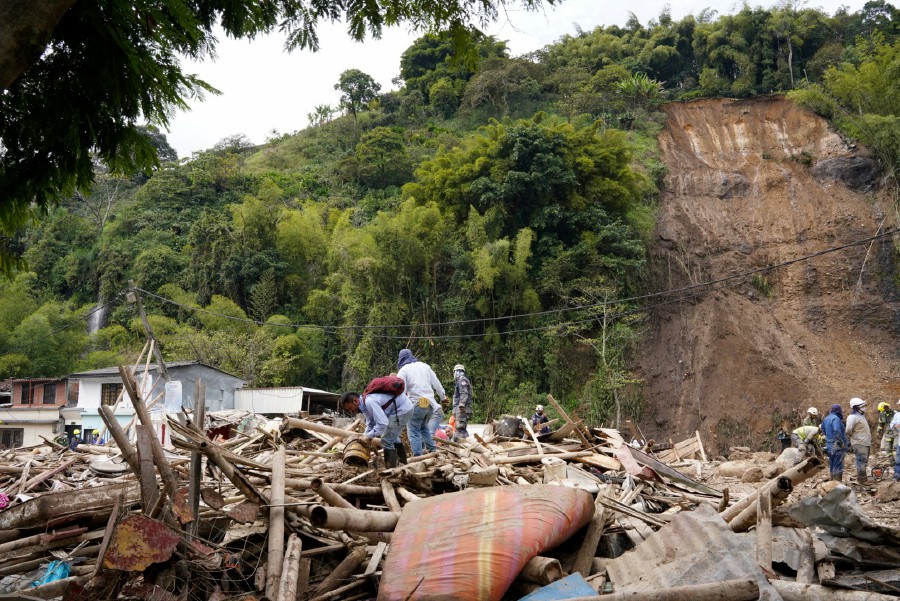 People remove debris following a landslide caused by heavy rains, that killed and injured residents and destroyed homes, in Pereira, Colombia. - REUTERS PIC