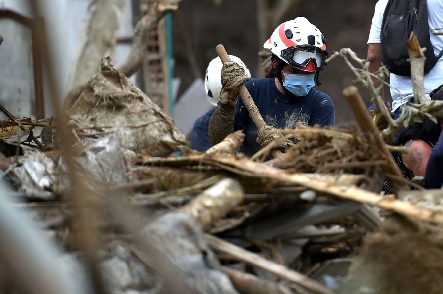 Rescuers remove debris during the search of victims after a landslide caused by heavy rains in Pereira, Risaralda department, Colombia. - AFP PIC