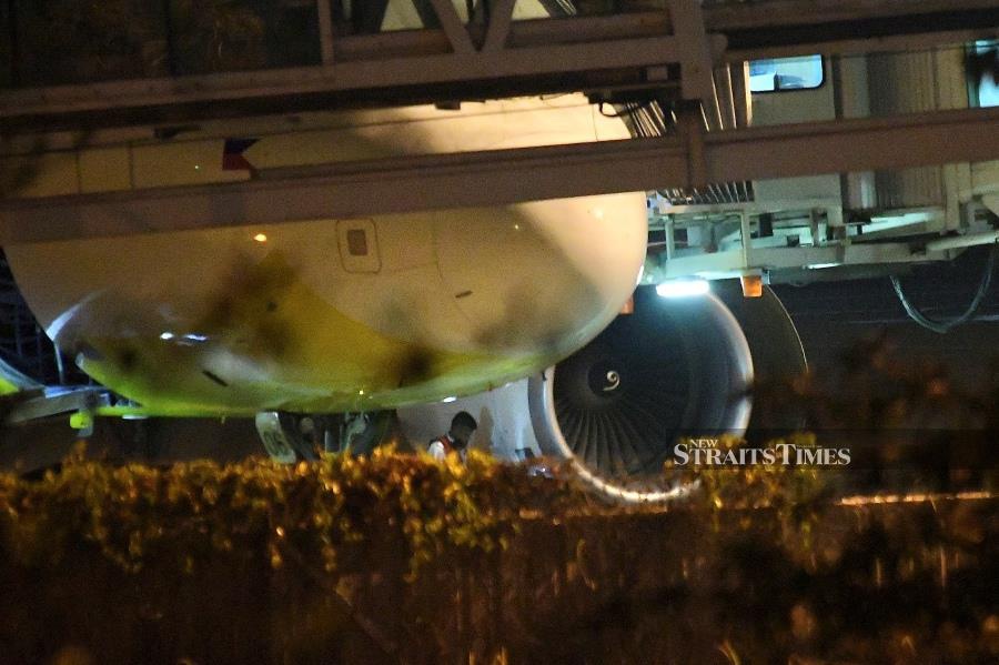 Engineers inspecting the plane following the emergency landing at the Kota Kinabalu International Airport in Kota Kinabalu. -NSTP/MOHD ADAM ARININ